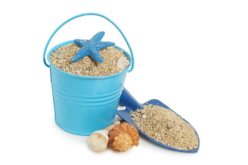 bucket, spade and seashells with sand, summer concept