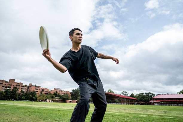 istock Young man throwing frisbee puck at the public park 1592672921