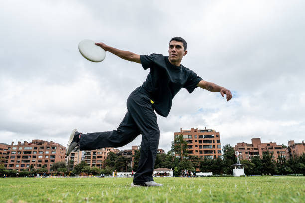 istock Young man throwing frisbee puck at the public park 1592672933