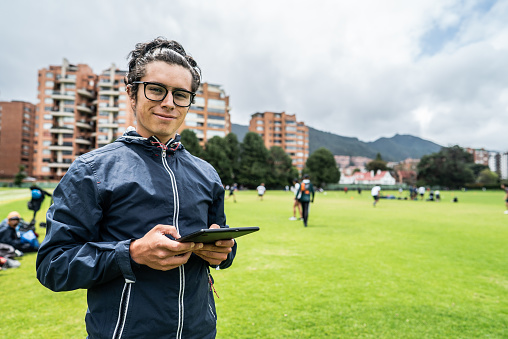Portrait of a young coach man using digital tablet on the sports field