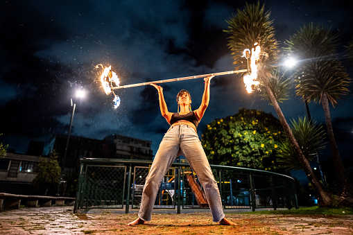 Fire show. Fakir dances with two Staff. Night performance. Fire and smoke. Fascinating flame movement. Subjugation of the elements of fire.