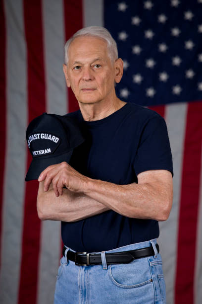 istock US Coast Guard Veteran looking at camera holding veterans cap 1592684475