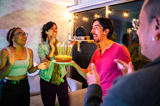 Mid adult man celebrating his birthday with friends at home
