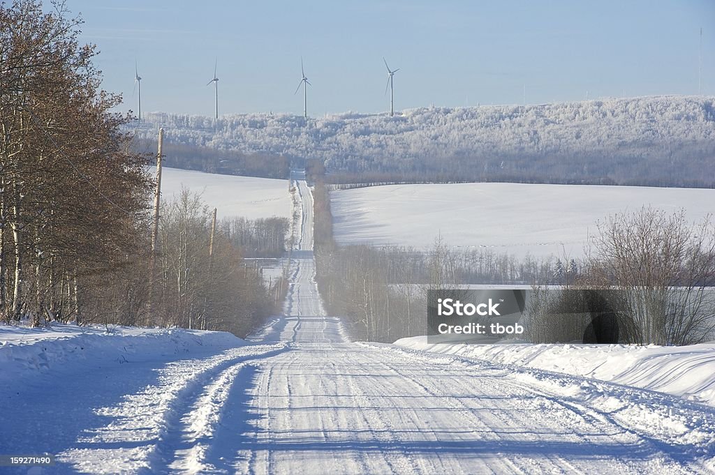 Strada di campagna invernale e turbine eoliche - Foto stock royalty-free di Inverno