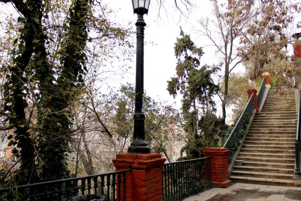 istock Stairs leading up, red columns and light in middle trees 1592752387