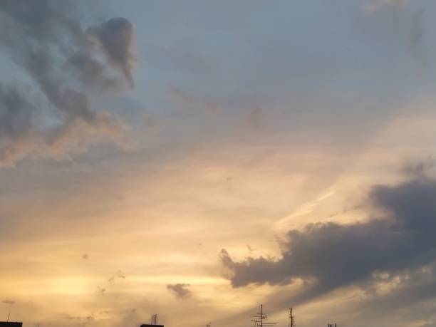 istock Beautiful dramatic sunset. The sky turned yellow. Dark gray clouds. Clouds lit by the lateral evening sun. Soft warm tones and colors. Summertime atmosphere. 1592755469