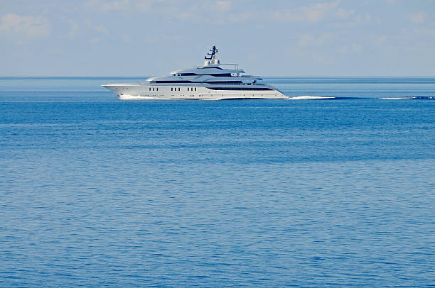 Evening. Brightly lit yacht parked in the Bay on the background of the Gelendzhik lighthouse.  The light is reflected beautifully in Gelendzhik Bay