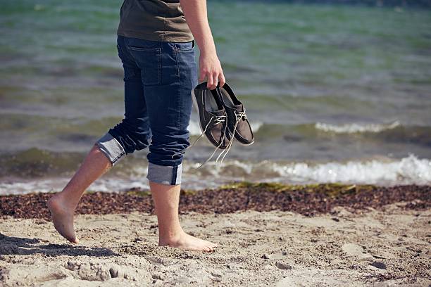 istock Barefoot Man Walking Along the Sandy Beach 159276408