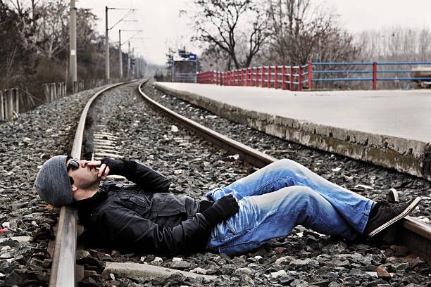 fresco giovane uomo smokin su ferrovia - violate foto e immagini stock