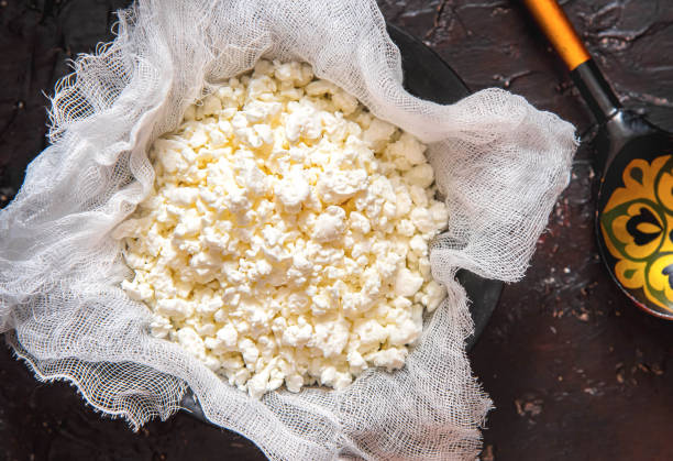 istock Fresh cottage cheese on gauze on a black background 1592772109