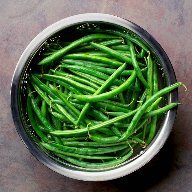 Fresh, organic string beans Colender full of freshly washed, organic garden string beans runner bean stock pictures, royalty-free photos & images