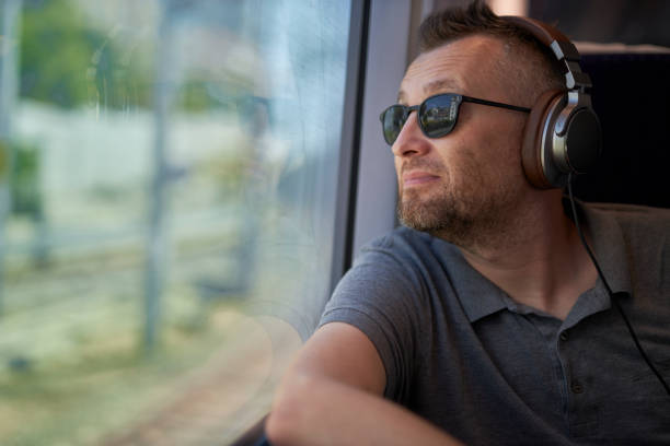 istock middle aged white man looking out of window in a train trip 1592815980