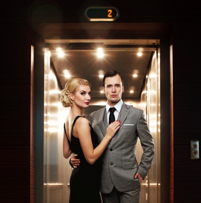 Retro couple standing against elevator.