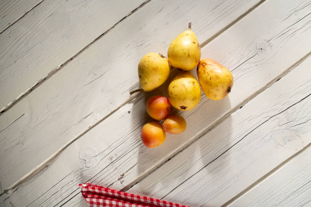Healthy eating. Pears and apricots are indispensable fruits for vegetarians. Top view on white wooden table.