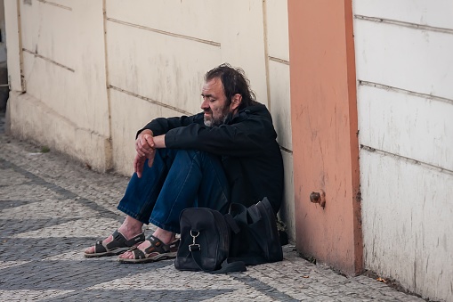 Prague, Czech Republic - August 18, 2010: An apparently homeless man sitting on the pavement.