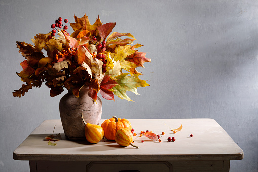 Autumn leaves bouquet with pumpkins and copy space