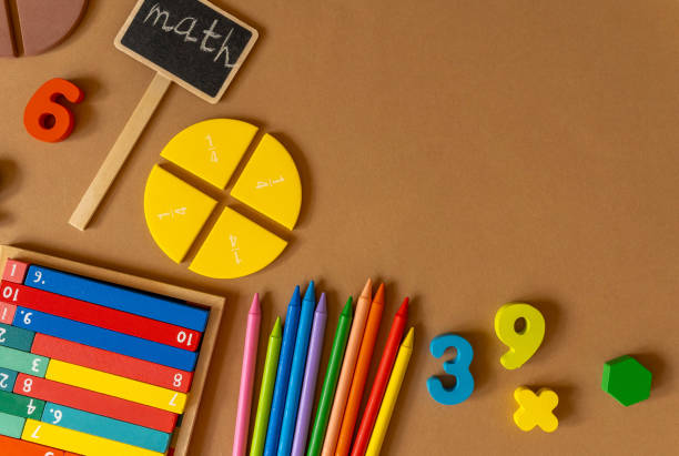 istock Colorful math fractions, numbers, letters on brown background. Interesting, fun, creative mathematics for kids. Education, back to school concept. Mathematical background 1592935077