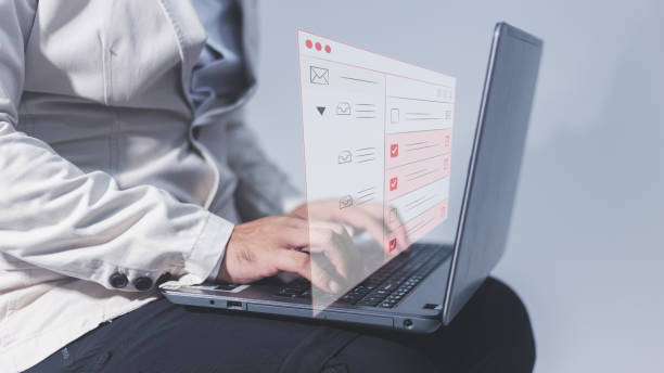 istock Man using a laptop computer with a checklist on the screen. Business concept. 1592962728