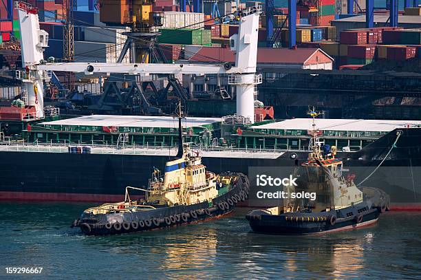 Foto de Navio De Carga No Porto E Tug Boat e mais fotos de stock de Dois Objetos - Dois Objetos, Navio rebocador, Amarelo