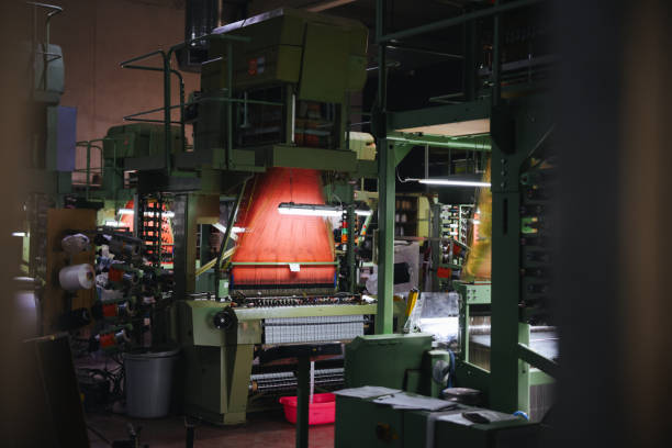 istock Colorful Threads on a loom in weaving loom machine in textile factory 1592988125