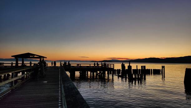 istock silhouette sunset view of mountain range, a pier and calm ocean water 1592996149