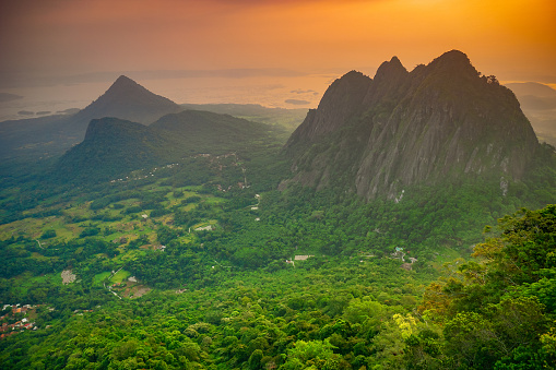 Serene Sunrise over Majestic Mountain Range in a Lush Forest Valley