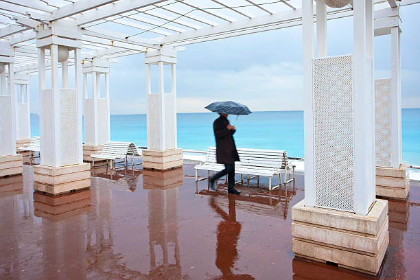 Nice walk The beach promenade at a rainy day in winter time. nizza wetter stock pictures, royalty-free photos & images