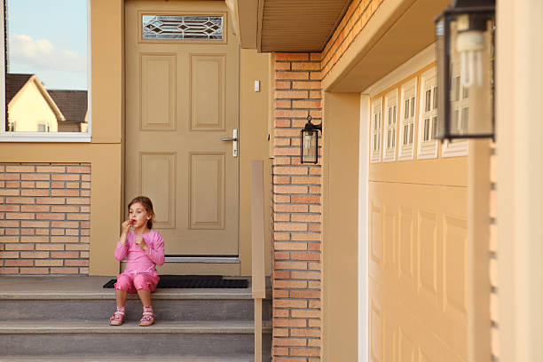istock Little girl sits on stairs and eats cookies. 159309852