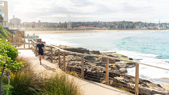 Asian man in sport clothing do sport training running workout exercise at seaside on summer sunny day.