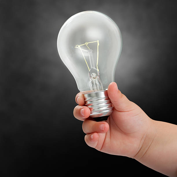 Baby hand holding light bulb.