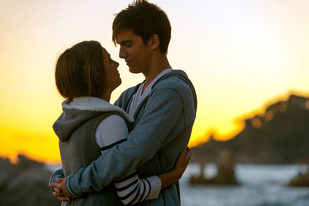 silhouette der romantisch paar bei sonnenuntergang. - teenage couple stock-fotos und bilder