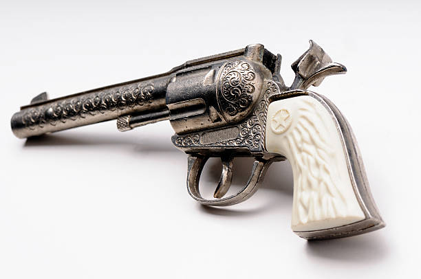 hand of a child holding and pointing a gun playing in a backyard