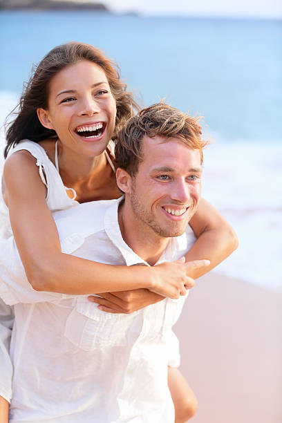 istock Happy couple piggybacking on beach. 159318087