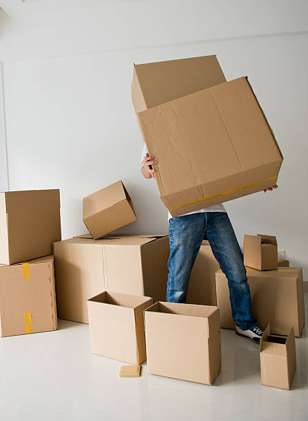 moving house Man struggling to carry boxes while moving house. big cardboard box stock pictures, royalty-free photos & images