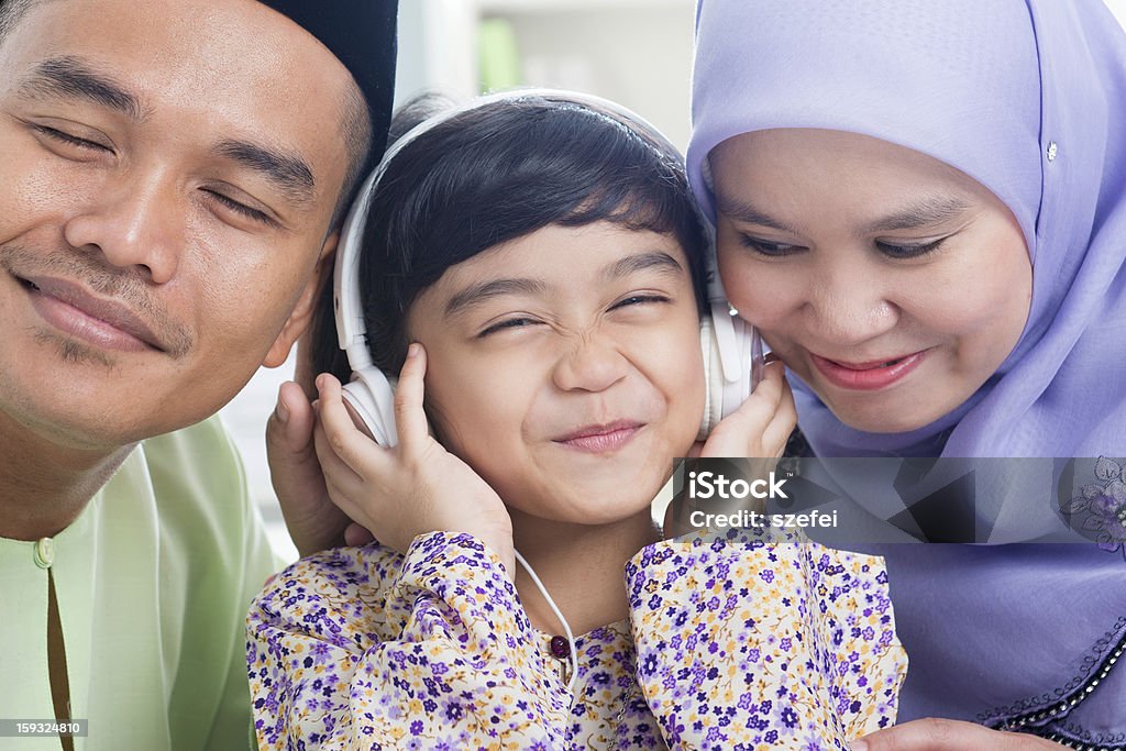 Southeast Asian family Southeast Asian family listen mp3, sharing headphone. Muslim family living lifestyle Family Stock Photo