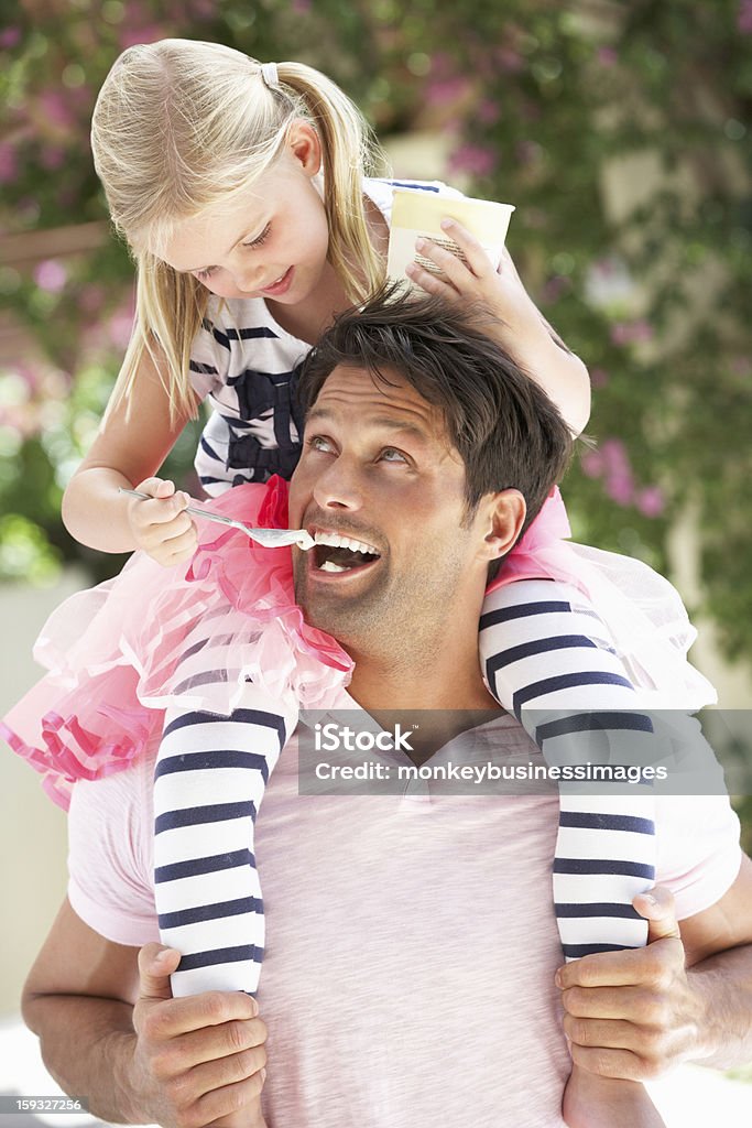 Father Giving Daughter Ride On Shoulders Being Fed Ice Cream Father Giving Daughter Ride On Shoulders Whilst Being Fed Ice Cream Smiling Ice Cream Stock Photo