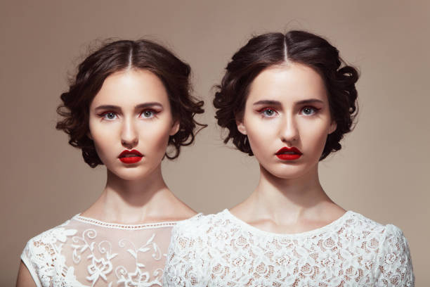 Beautiful twins Studio portrait of two beautiful twins. Professional make-up and hairstyle. High-end retouch. gray eyes photos stock pictures, royalty-free photos & images