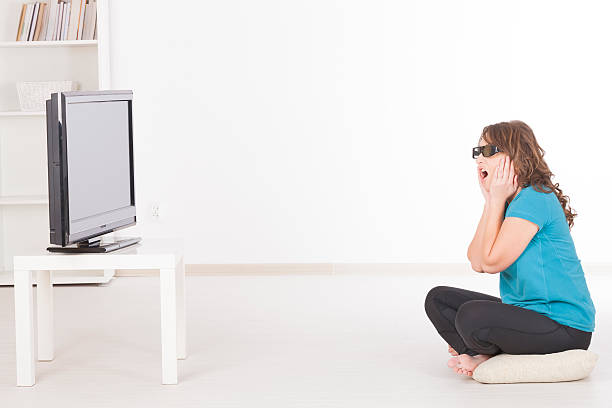 istock woman watching 3D TV in glasses 159330065