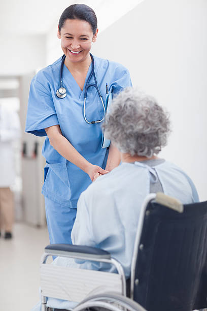 istock Nurse smiling while holding the hands of patient 159332505