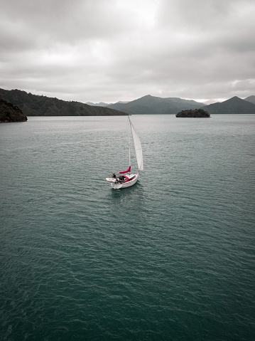 A lone sail boat, sailing in the marlborough sounds. This image was taken from a drone.