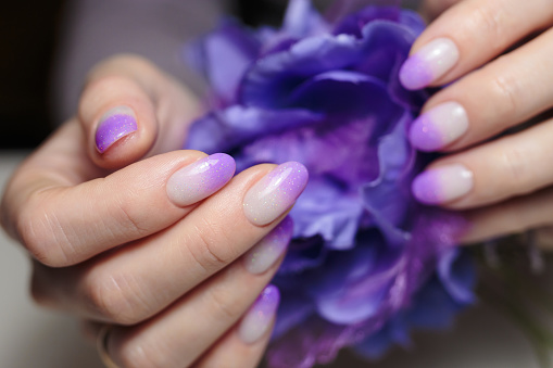 Nail art and design ideas. Artistic manicure with gradient violet glitter nail polish