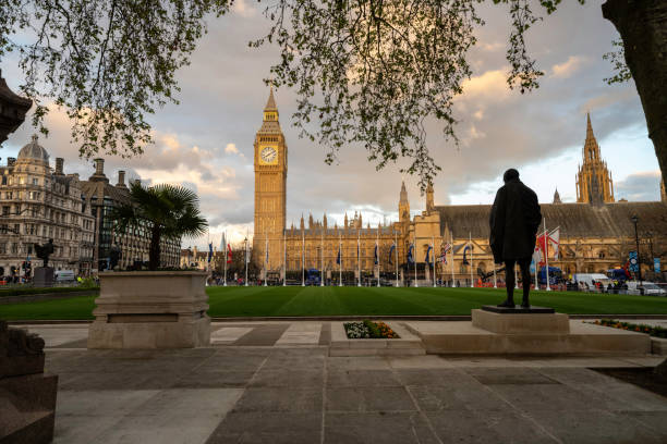 paisagem urbana londrina do parliament square garden e da torre elizabeth, big ben no palácio de westminster ao pôr do sol. a popular praça da cidade de westminster está repleta de atividades para a próxima coroação do rei carlos iii. - corrie - fotografias e filmes do acervo