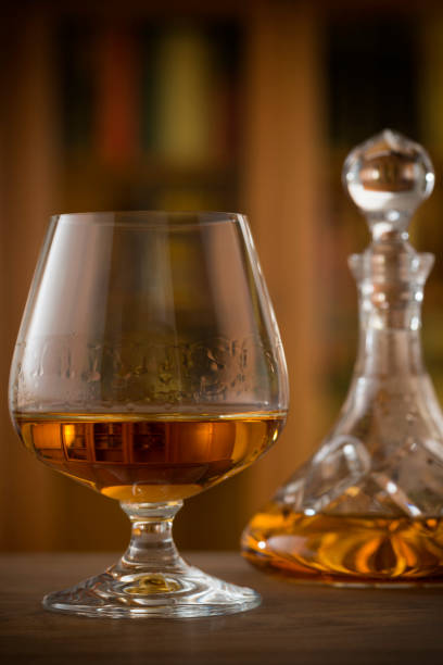View at a glass of Cognac or Brandy may be it is inside a library. Vignette added or that vintage look.