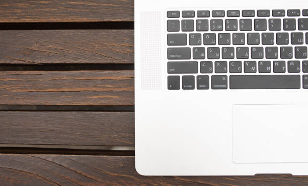 Modern laptop computer on brown wooden background. Technology concept.