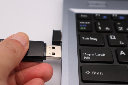 Photo of a person inserting a USB memory into a computer