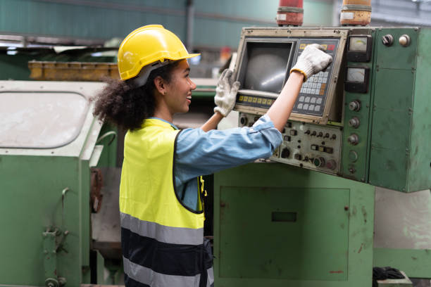 african american Industry engineer woman inspect control cabinet machine in industrial factory . black female mechanical technicians checking or working with heavy machine stock photo