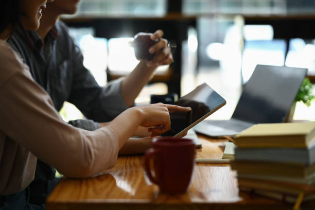 istock Cropped shot of university students using digital tablet, discussing research, learning tasks together. 1593464814