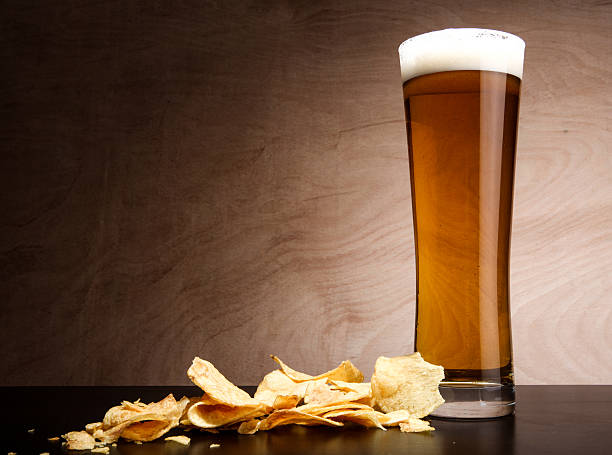 Glass with beer and crisps stock photo