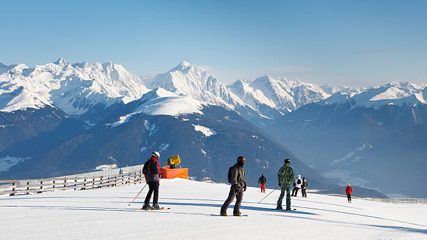 Skiers enjoy the fantastic alpine panorama on a sunny winter day.