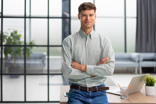 istock Handsome young businessman standing in modern office. 1593490354